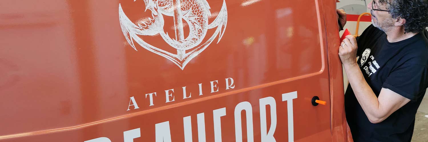 Technicien de bixoko effectuant un habillage de véhicule dans notre atelier d'impression à Bayonne