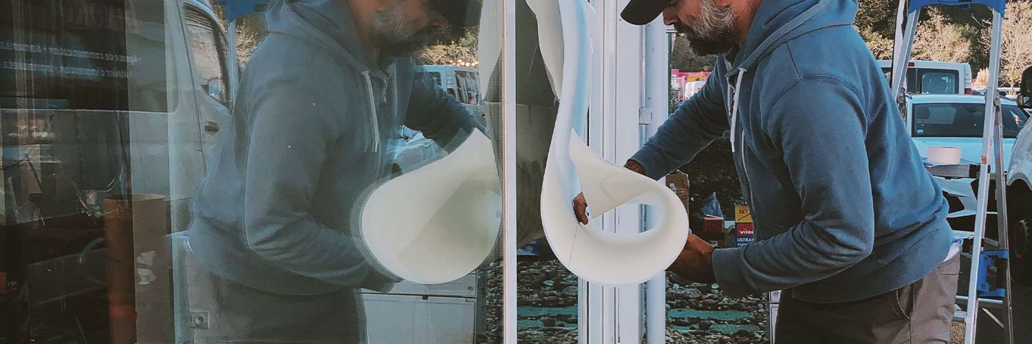 Technicien poseur en train de poser une vitrine à Biarritz